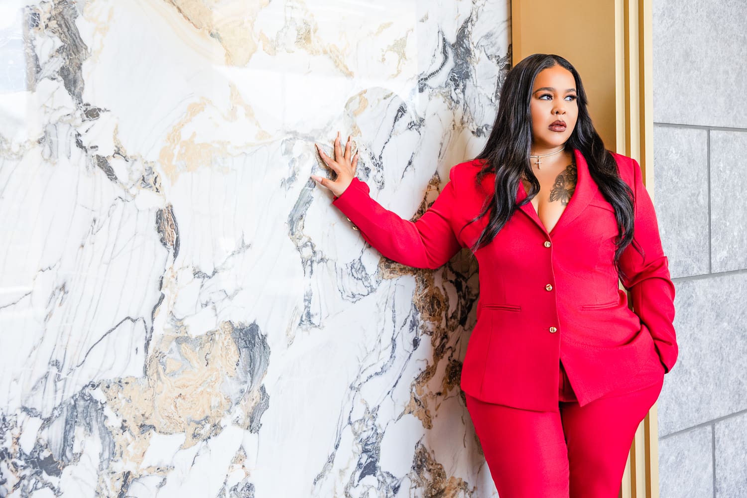 lady wearing a red two piece suit looking away from the camera not smiling