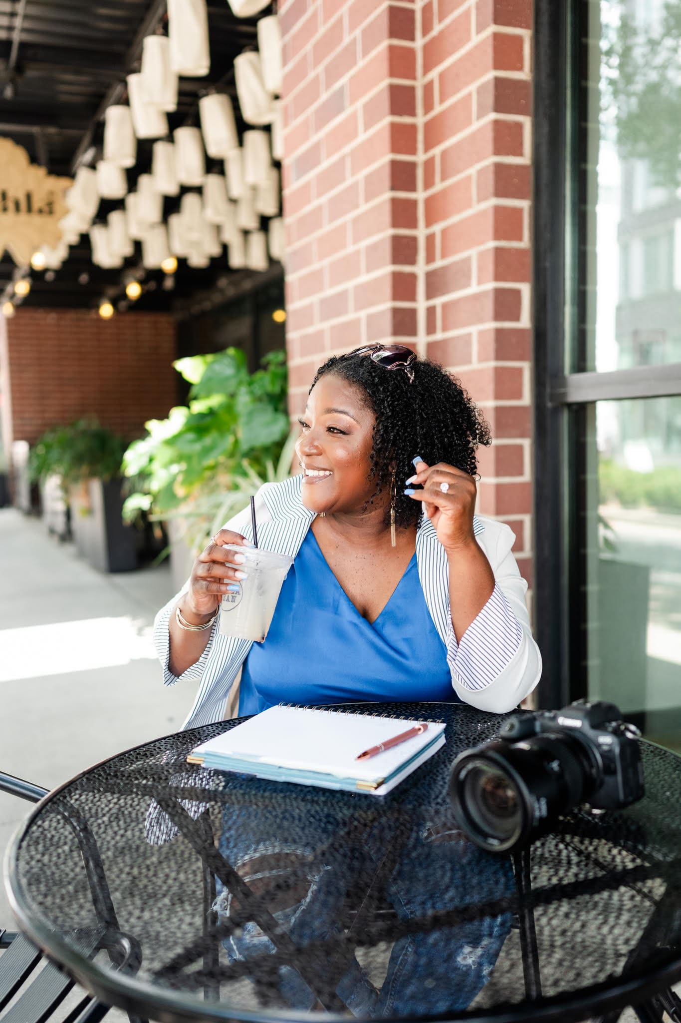 Shenica Powe sitting outdoors with her laptop while reflecting on trying new things in business.