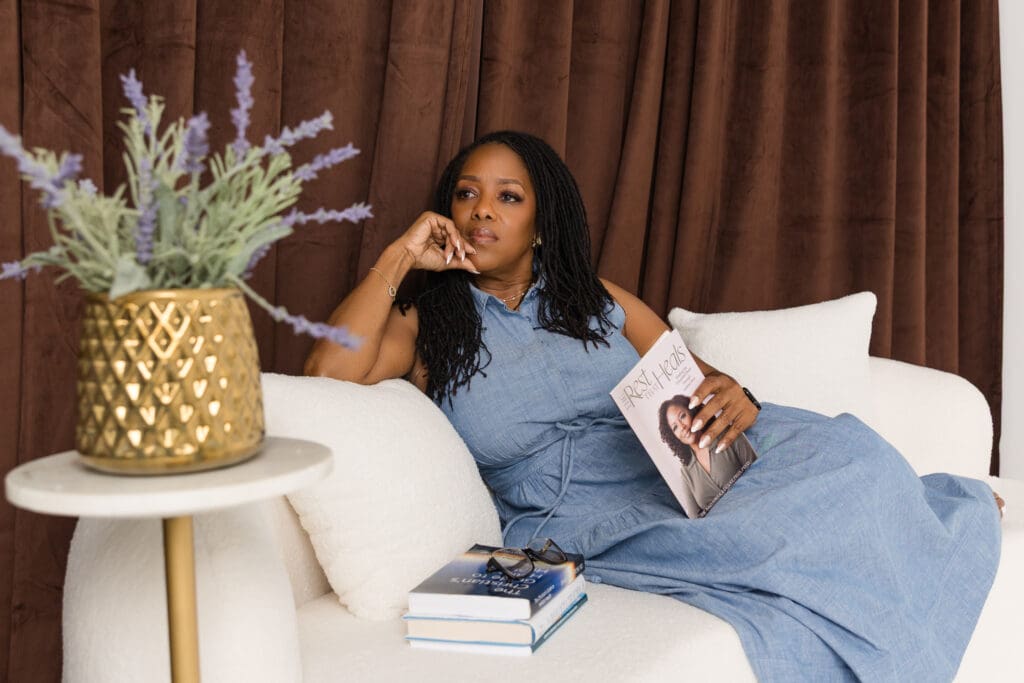 Woman relaxing on a white sofa while holding a magazine during her personal branding session.